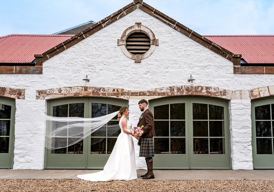 Bride and groom in front of Kinclune Steading